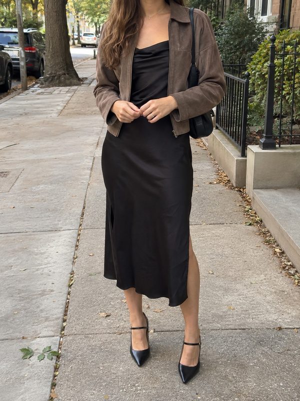 Example outfit cropped below the face: a black satin slip midi dress with a brown suede jacket and black pointed heels.