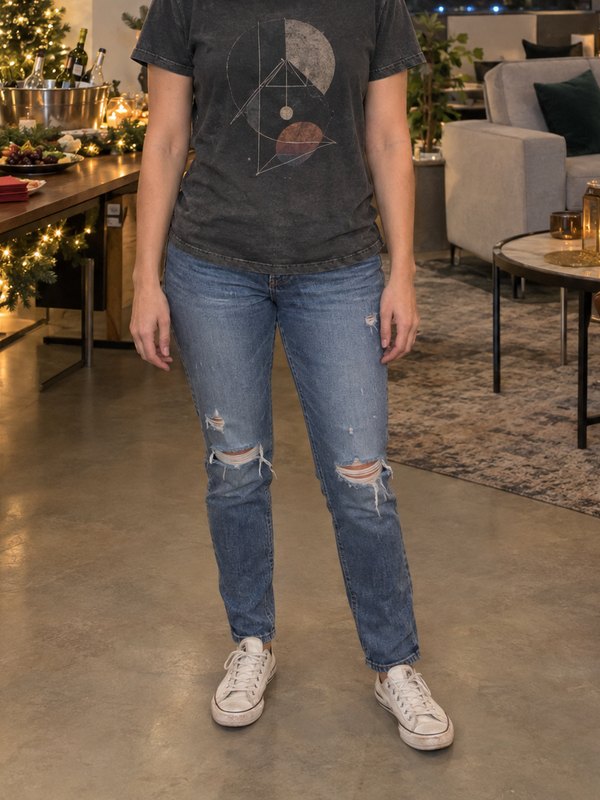 Example outfit cropped below the face: a grey graphic tee, ripped light-wash jeans and white canvas sneakers at an office holiday party.