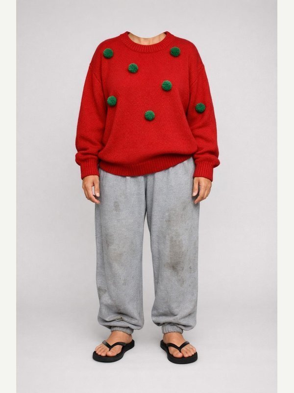 Oversized red novelty sweater with green pompom decorations, baggy stained gray sweatpants and rubber flip-flops.